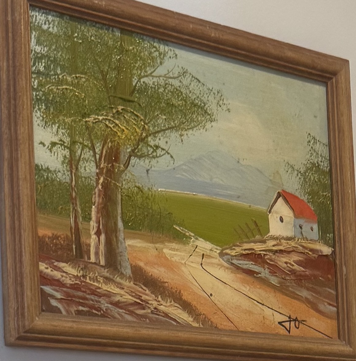 Oil painting of a white house with a red roof beneath tall trees