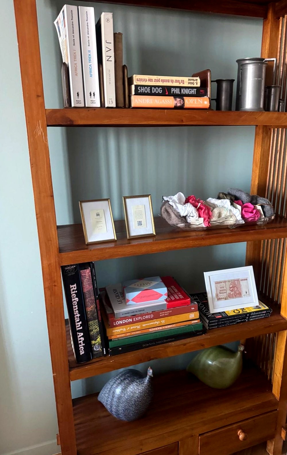 A glass bowl of silk and cashmere chouchous on the bookshelf in the apartment