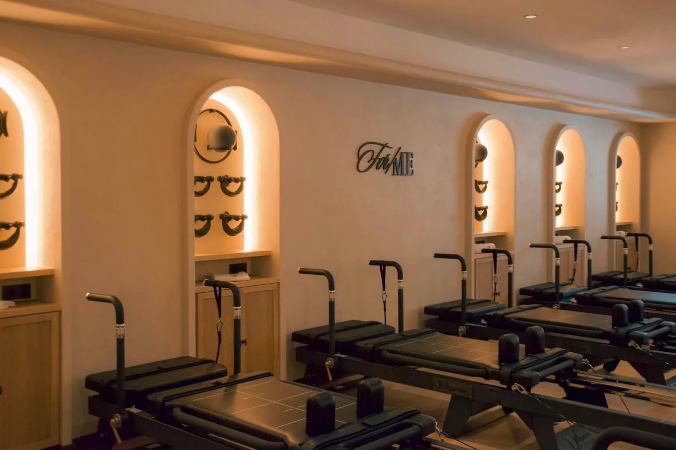 The For/Me reformer studio, machines set into lit arched alcoves