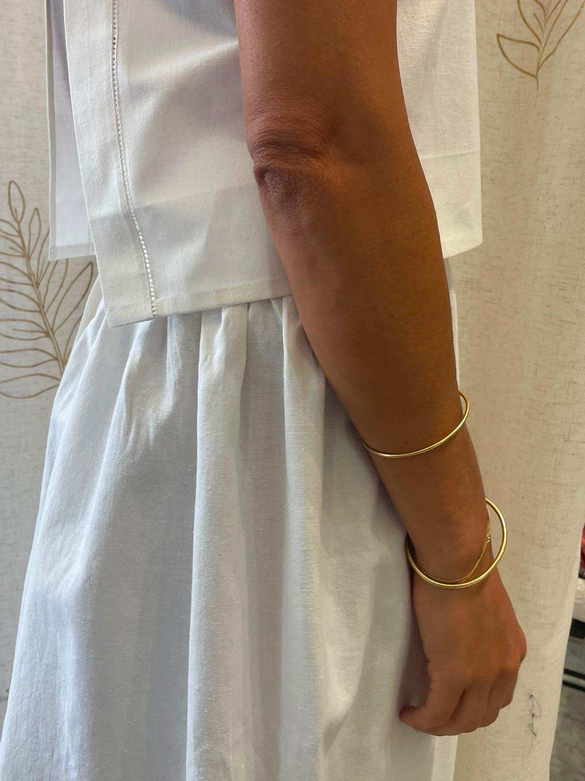 Side view of the linen top and skirt with gold bangles